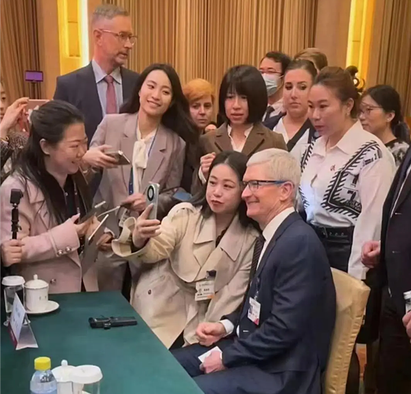 Vào ngày 25/3, một người phụ nữ đã dùng Huawei Mate60 để chụp ảnh selfie với Tim Cook tại một sự kiện ở Trung Quốc.Nguồn ảnh: Kuai Technology