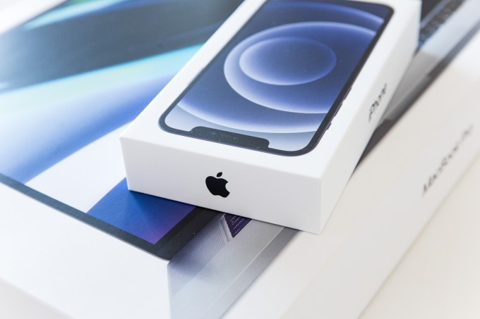 Ảnh chụp hộp đựng iPhone 12 mới đặt trên hộp đựng MacBook Pro.
