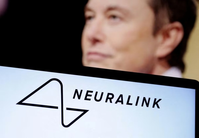 Logo Neuralink hiển thị trên máy tính xách tay, theo sau là hình ảnh của Musk. Ảnh: Reuters